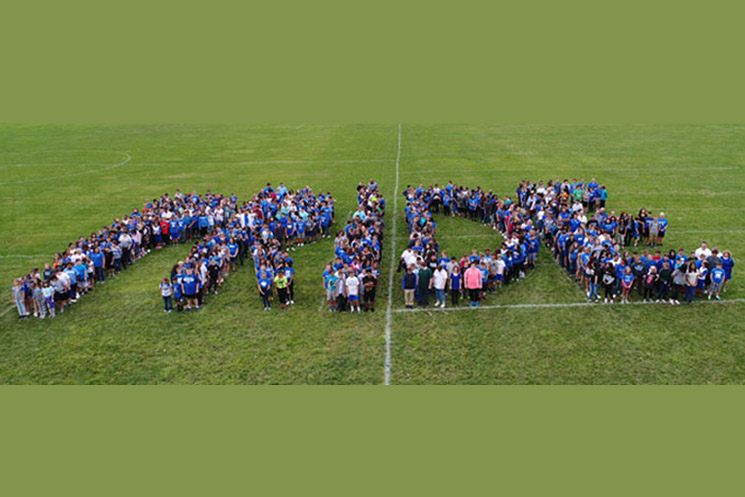 Students from Springbrook elementary create the word PRIDE while standing on the football field.