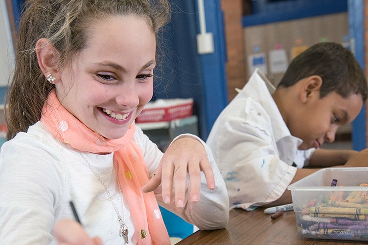 Girl smiling while coloring.